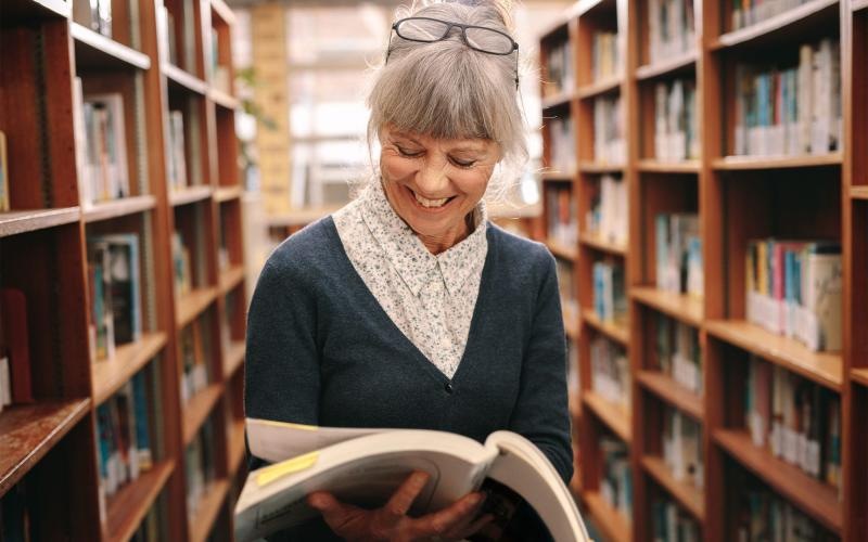 a woman reading a book in a library