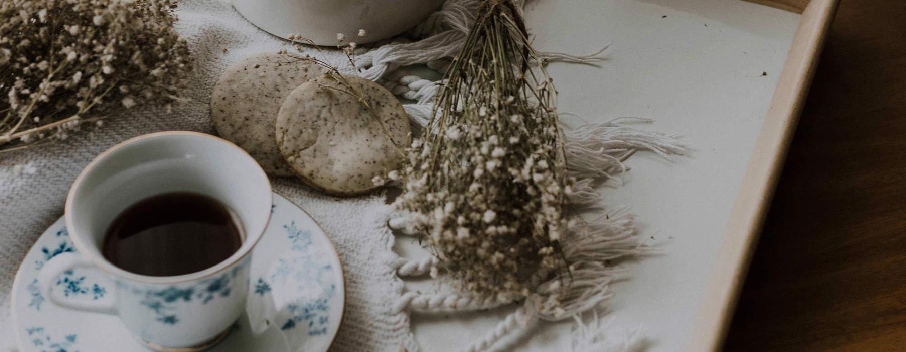 tea and cookies on a serving tray with baby's breath