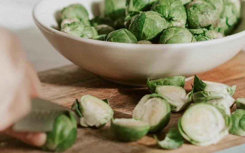 a person cutting brussel sprouts